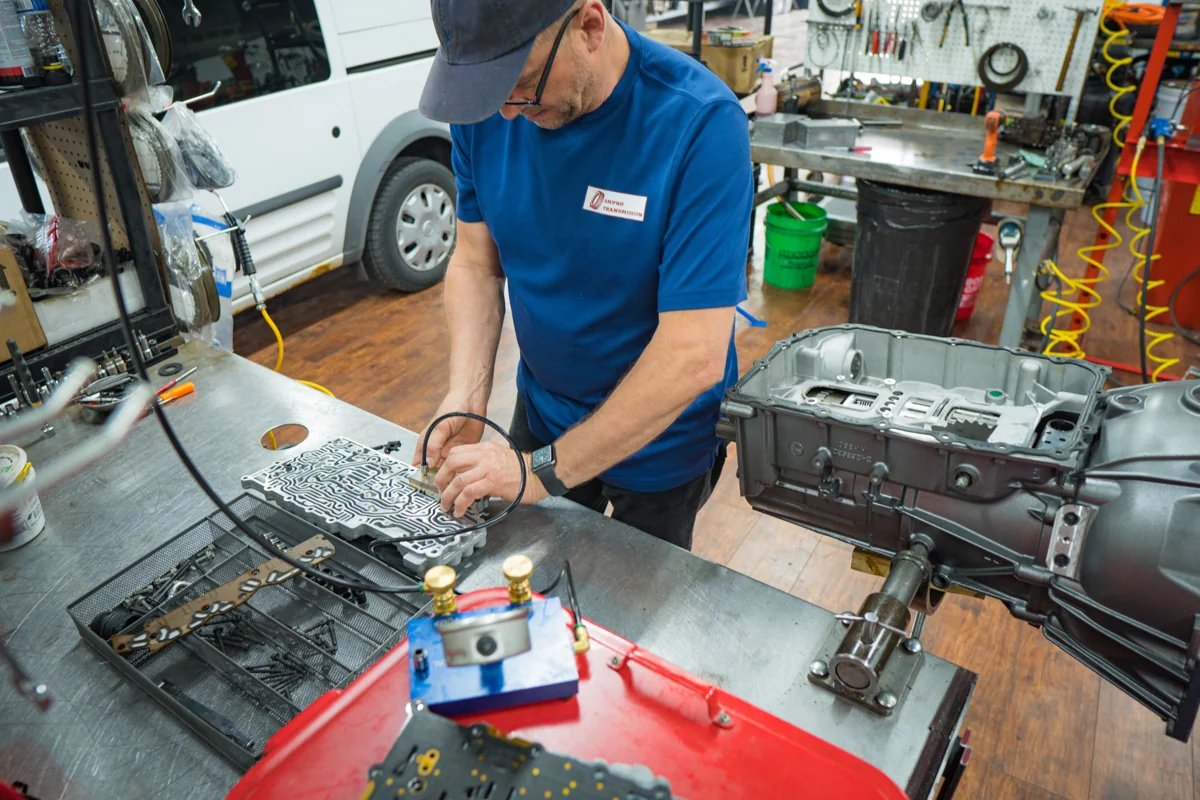 An AMPro technician working on transmission components at the bench